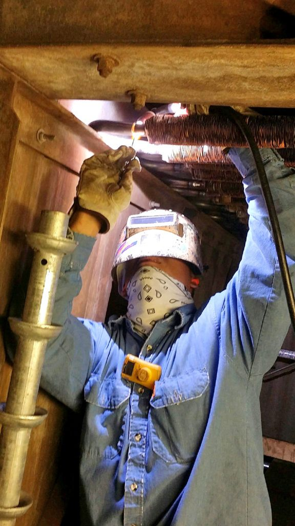 Welder working inside a unit during a turnaround